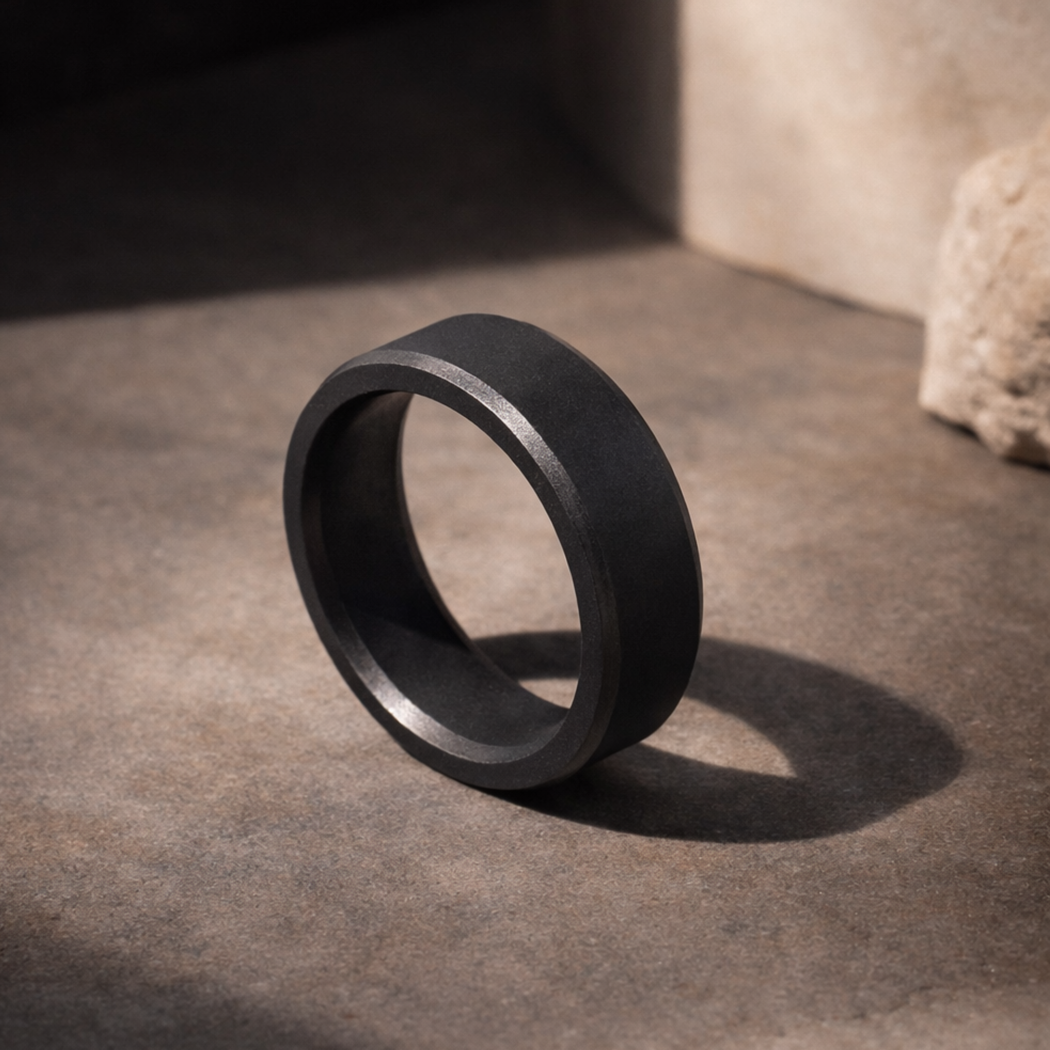 ARES solid black diamond wedding band in 8mm polished finish, displayed on a refined stone surface