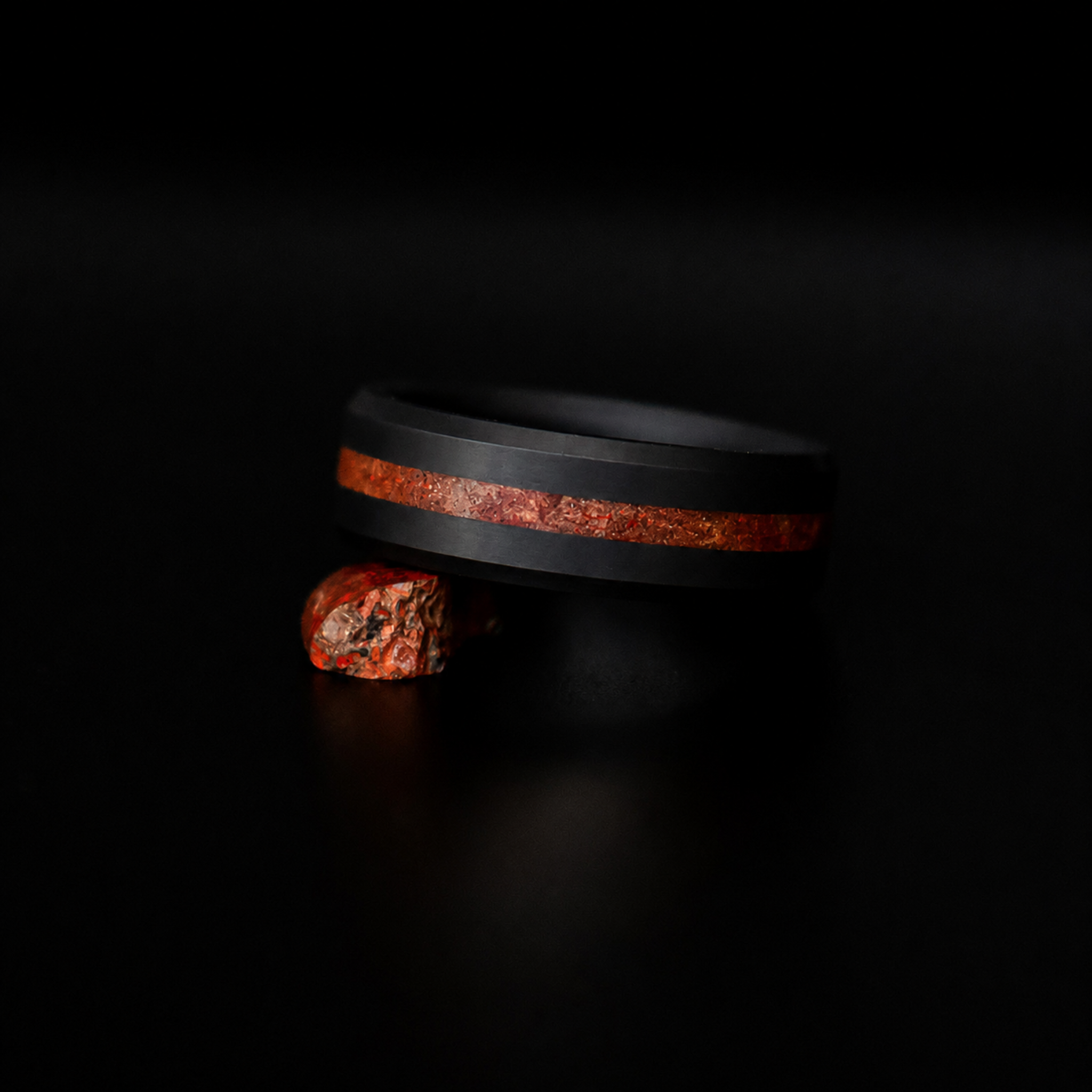 ARES dinosaur bone inlay wedding band in solid black diamond, dark editorial view