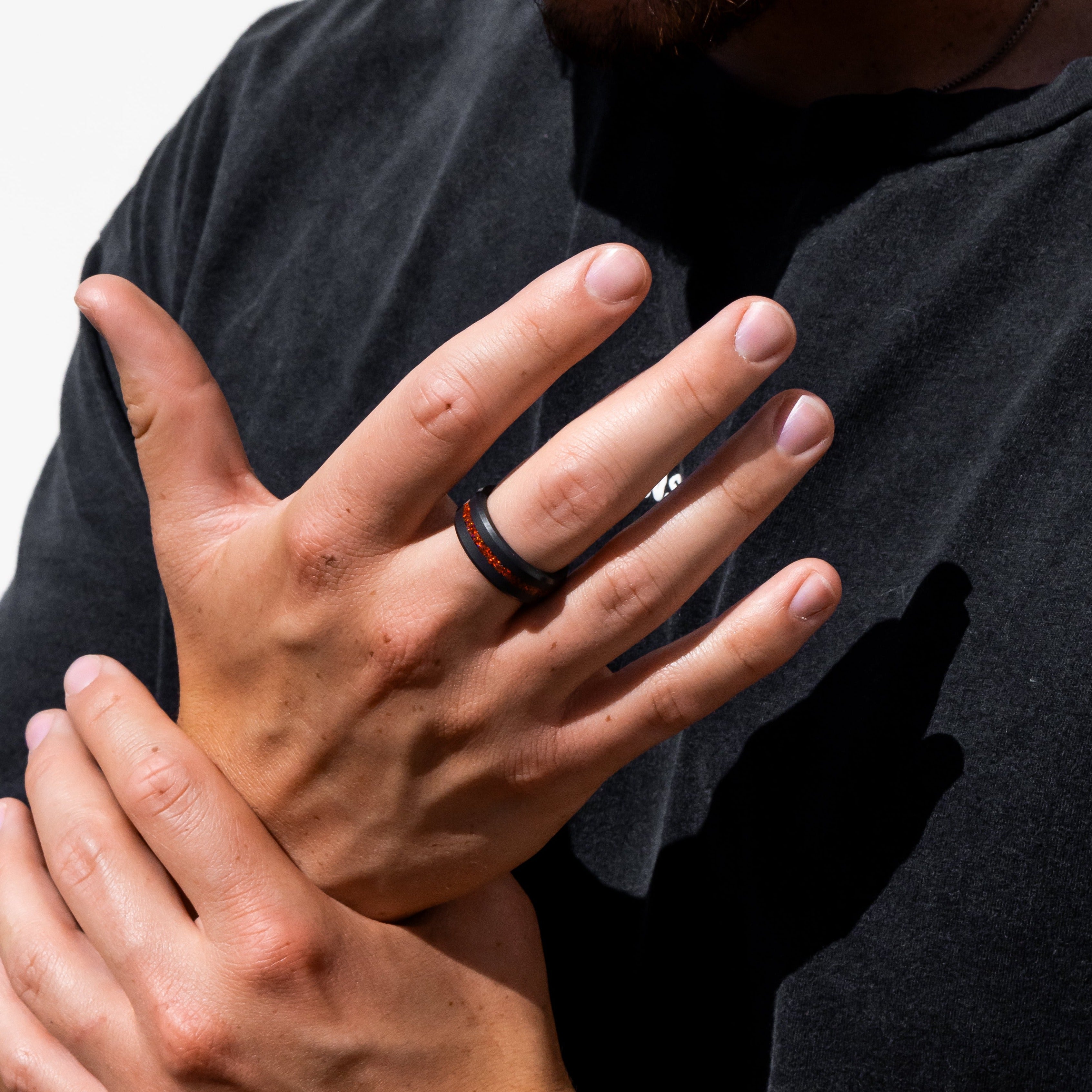 Lifestyle shot #1 of men's hands wearing our Elysium ARES Men's Black Diamond & Red Opal ring | ElysiumBlack.com | Men’s Opal Rings | Opal Rings for Men