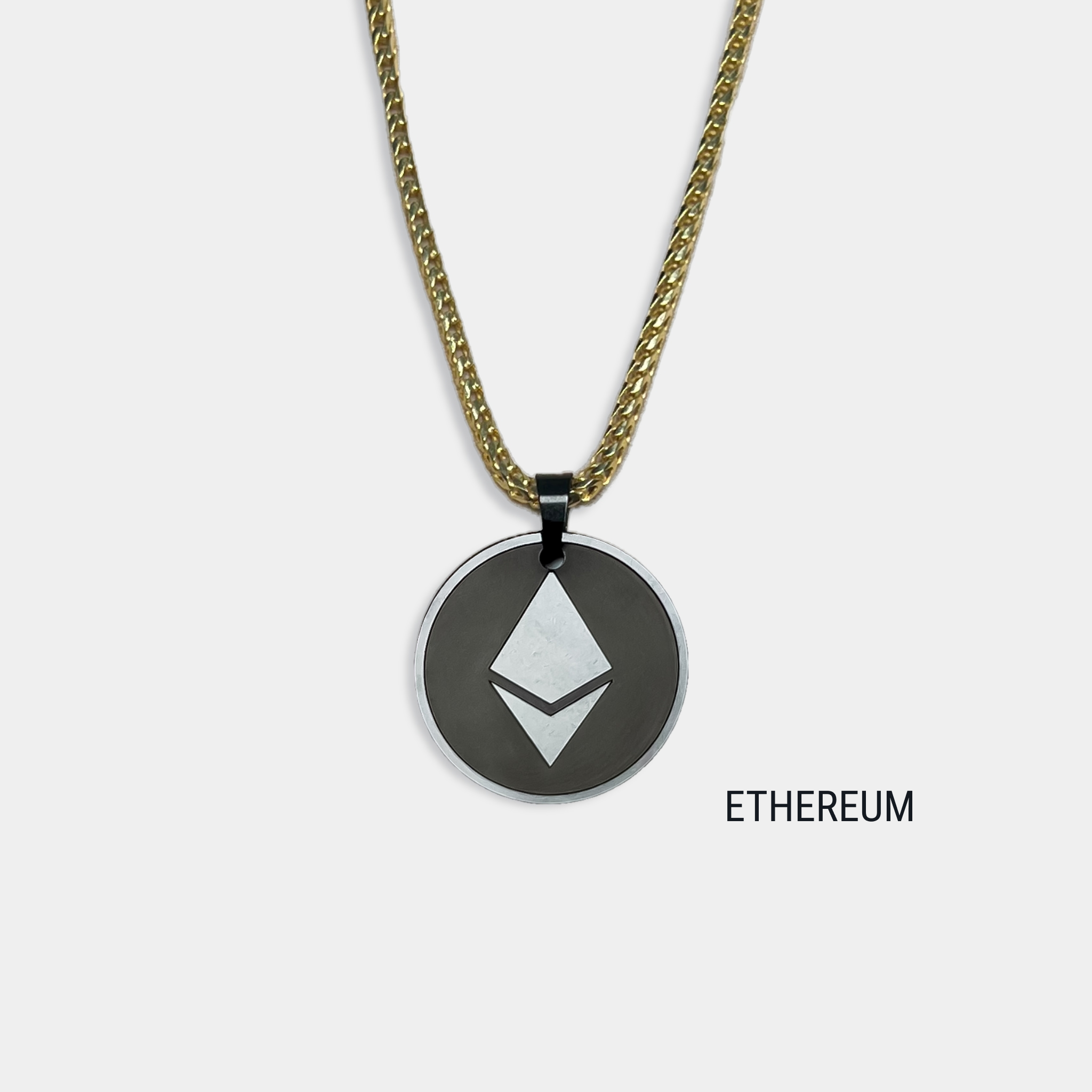 Photo of round solid black diamond pendant with ethereum symbol engraved, attached to gold chain